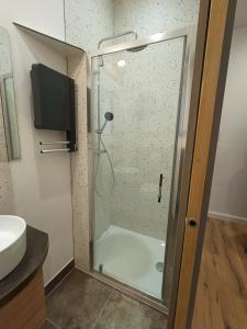 y baño con ducha y puerta de cristal. en Le 28 Frater, en Millau