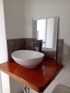 a bathroom with a white sink and a mirror at Bungalow VerdeMar con Jacuzzi Frente al Mar in Vichayito