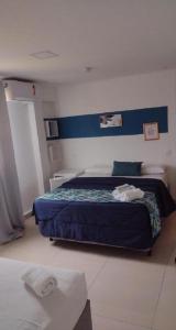 um quarto com uma cama com uma cabeceira azul em Costa Maris Beach Hotel Frente Mar no Guarujá