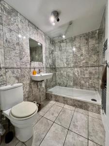 倫敦的住宿－Great 2 bedrooms apartment 15 mins from the centre，浴室配有卫生间、浴缸和水槽。