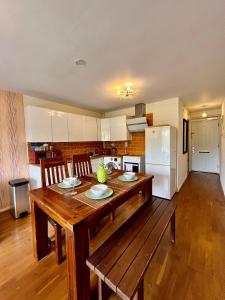 a kitchen with a wooden table and a refrigerator at Great 2 bedrooms apartment 15 mins from the centre in London