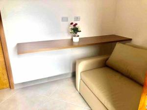 a living room with a couch and a wooden shelf at Rafael Apartamentos 800m da Praia da Maranduba in Ubatuba +169 photos