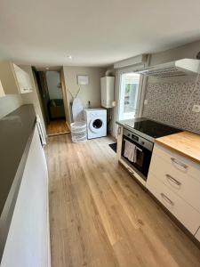 a kitchen with a stove top oven next to a washing machine at Maison de ville Atypique - centre ville in Lannion