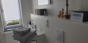 La salle de bains est pourvue de placards blancs, d'une fenêtre et de serviettes. dans l'établissement Nummer 13 - Altstadthaus, à Petershagen