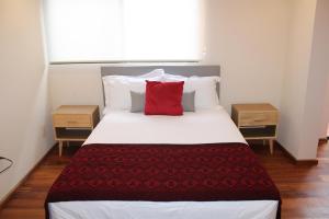 1 dormitorio con cama grande y almohada roja en Casa Luna Coyoacan, en Ciudad de México