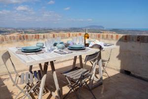 uma mesa com pratos e copos e uma garrafa de vinho em Dimora Pallotto em Potenza Picena