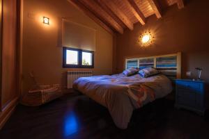 um quarto com uma cama grande e uma janela em La Portilla de Gredos. Casa rural em Hoyos del Espino