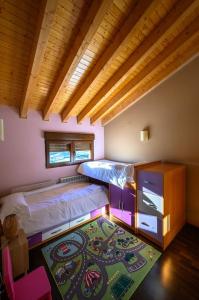 um quarto com 2 beliches e um tapete em La Portilla de Gredos. Casa rural em Hoyos del Espino