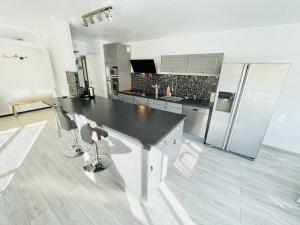 a kitchen with a black counter and a refrigerator at Flatshare 5 Colocation close to Geneva in Saint-Genis-Pouilly