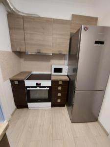 eine Küche mit einem Kühlschrank und Schränken aus Edelstahl in der Unterkunft Blue Flag Glyfada Center in Athen