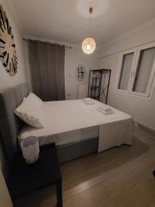 ein Schlafzimmer mit einem großen weißen Bett und einem Tisch in der Unterkunft Blue Flag Glyfada Center in Athen