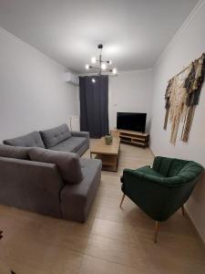 ein Wohnzimmer mit 2 Sofas und einem TV in der Unterkunft Blue Flag Glyfada Center in Athen
