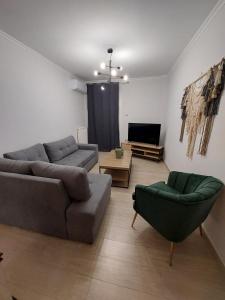a living room with two couches and a tv at Blue Flag Glyfada Center in Athens