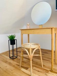 a dressing table with a mirror and a stool at Minimalist Apartment in Sofia