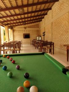 a pool table in a room with tables and chairs at Pousada Alto do Sossego in Rio de Contas