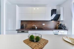 a kitchen with white cabinets and a basket of plants at Jean-Marie in Zaton