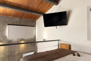 een slaapkamer met een bed en een flatscreen-tv aan de muur bij 2nd Home in Celaya