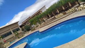 une grande piscine bleue en face d'un hôtel dans l'établissement Pousada Alto do Sossego, à Rio de Contas