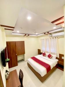 a bedroom with a large bed and a table and a desk at Prabhuvihar Residency in Porvorim