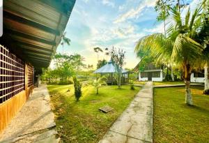 une cour avec une maison et une pelouse arborée dans l'établissement Hotel Karupa Amazonas, à Leticia