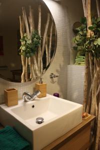 a white sink in a bathroom with a mirror at Cocon d'Argile in Bischoffsheim