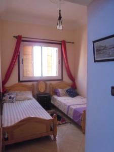 two beds in a room with a window at Seaside House in Imsouane