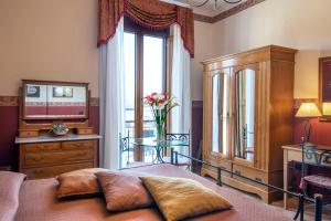 um quarto com uma cama, uma mesa e uma janela em Pinto-Storey Hotel em Nápoles mais 37 fotografias