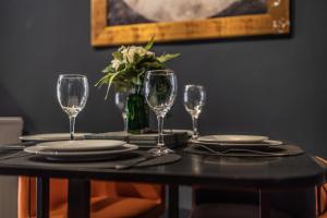 a table with plates and wine glasses on it at Boutique family apartment in celebrity village. in Barnt Green +5 photos