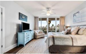 een slaapkamer met een bed, een televisie en een bank bij Caribe Resort Unit C211 in Orange Beach