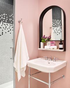 La salle de bains est pourvue d'un lavabo et d'un miroir. dans l'établissement The Neighborhood Hotel Lincoln Park, à Chicago