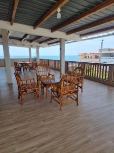 a patio with wooden chairs and tables on a deck at CRUCITALIA Departamento x 8 in Crucita