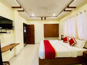 波尔沃林Prabhuvihar Residency的一间卧室，配有一张床、一张书桌和一台电视