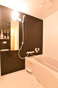 La salle de bains est pourvue d'une baignoire et d'un miroir. dans l'établissement FL House 浪花町, à Osaka