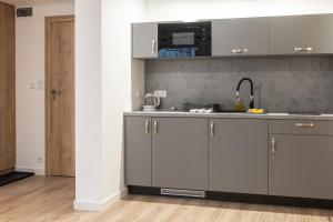 Una cocina con gabinetes blancos y un fregadero. en Apartamenty Aspen, en Karpacz