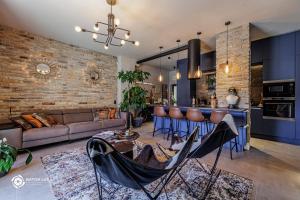 una cucina e un soggiorno con bar e divano di Bükk Penthouse, panoráma jacuzzival a Miskolc
