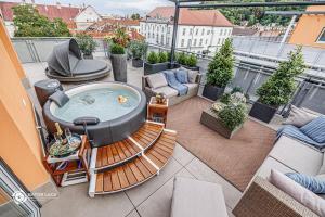 a patio with a hot tub on a balcony at Bükk Penthouse, panoráma jacuzzival in Miskolc