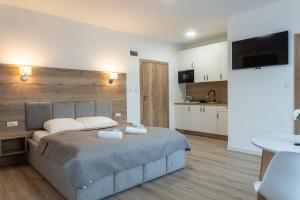 a bedroom with a large bed and a kitchen at Apartamenty Aspen in Karpacz