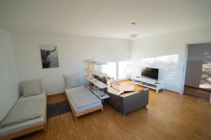 ein Wohnzimmer mit einem Sofa und einem TV in der Unterkunft Gemütliches Apartment mit Fernblick auf die Stadt! in Trier