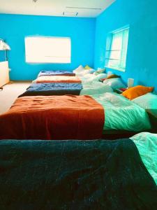 a row of beds in a room with blue walls at ABURA HAUS - Vacation STAY 13195 in Tokyo