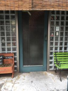a green door of a house with a green bench at ABURA HAUS - Vacation STAY 13195 in Tokyo
