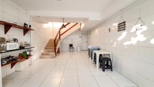 uma cozinha com pisos em azulejo branco e uma escadaria em Pousada Paraiso de Arempebe em Arembepe