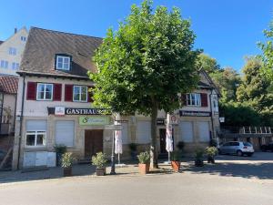 a building with a tree in front of a street at Gasthaus Lamm in Waldenbuch