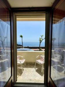 uma porta de vidro com vista para um pátio com cadeiras em Nice Sicily Little family home em Acireale