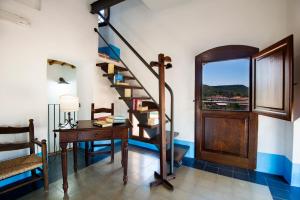 a room with a staircase and a desk and a window at Castello Malicas in Galtellì