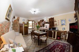 kuchnia i salon ze stołem i kanapą w obiekcie Holiday House Antica Dimora Soggiorni in langa centro storico La Morra w mieście La Morra