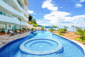 een zwembad voor een gebouw met uitzicht op de oceaan bij Blue Horizon 705 in Puerto Vallarta