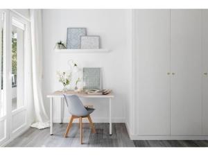 een witte kamer met een bureau en een stoel bij Fantastic flat with terrace Arturo Soria D2 in Madrid