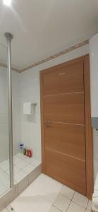 a bathroom with a wooden door in a room at Allées historiques du Parc de la Colombière, appt haut de gamme in Dijon