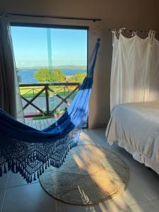a hammock in a room with a bed and a window at Eco Resort Pedra Bonita in Santo Estêvão