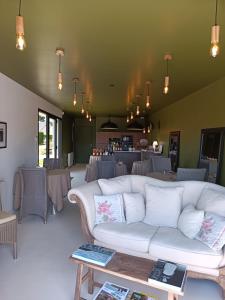 a living room with a white couch and tables at Maison Bailly in Ducey